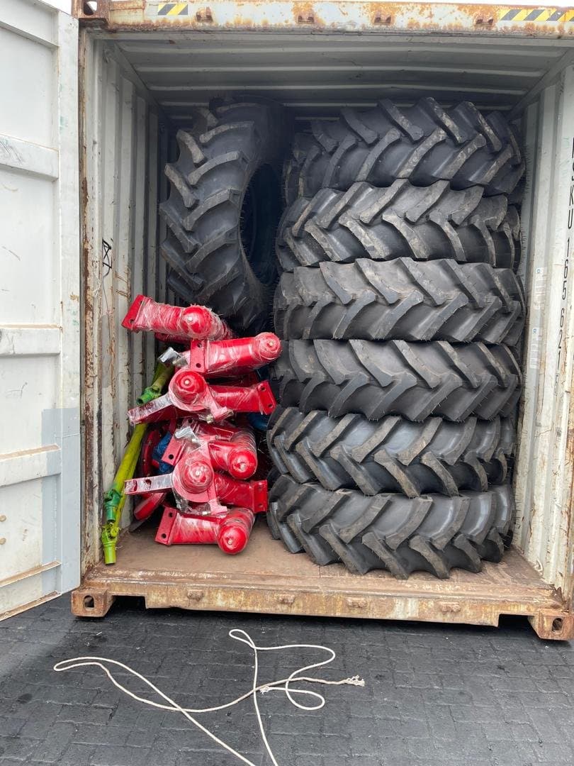 Shipping container packed with tractor tires and implement parts