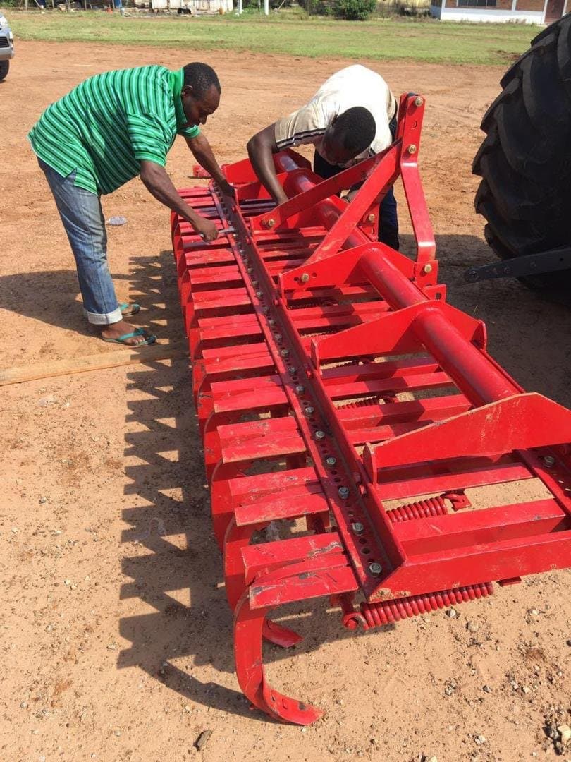 Workers assembling a disc harrow implement