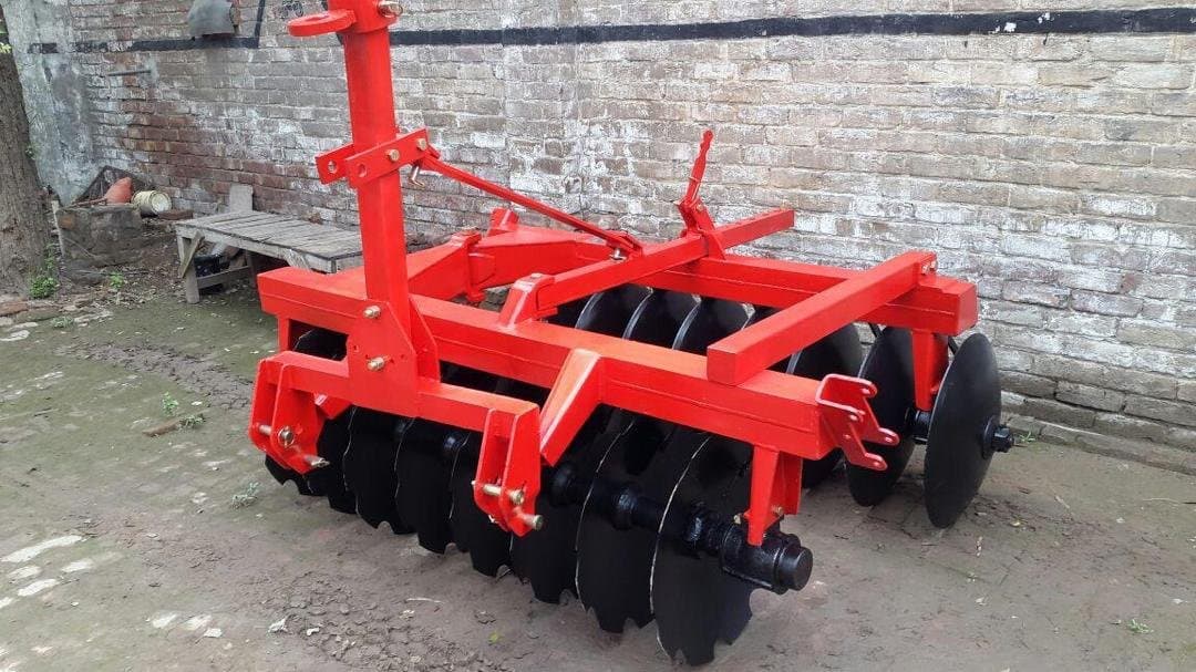 Disc harrow set against a brick wall in storage