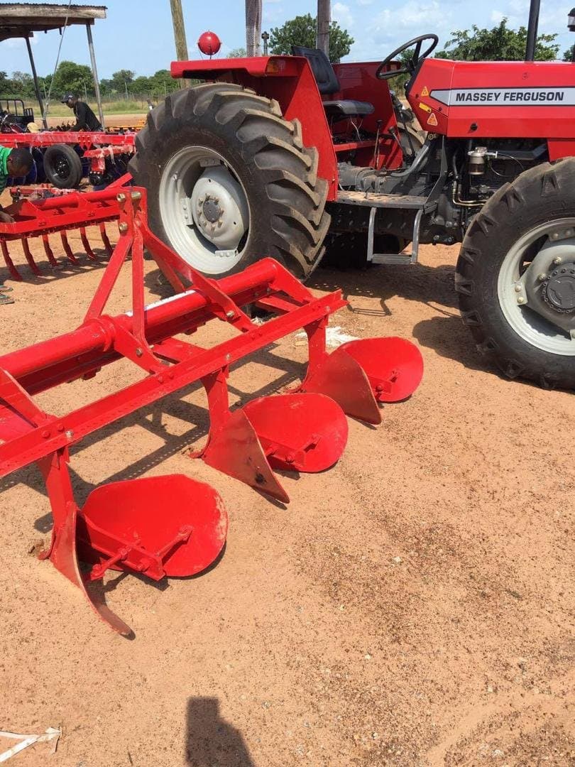 Disc plough beside a Massey Ferguson tractor in the field