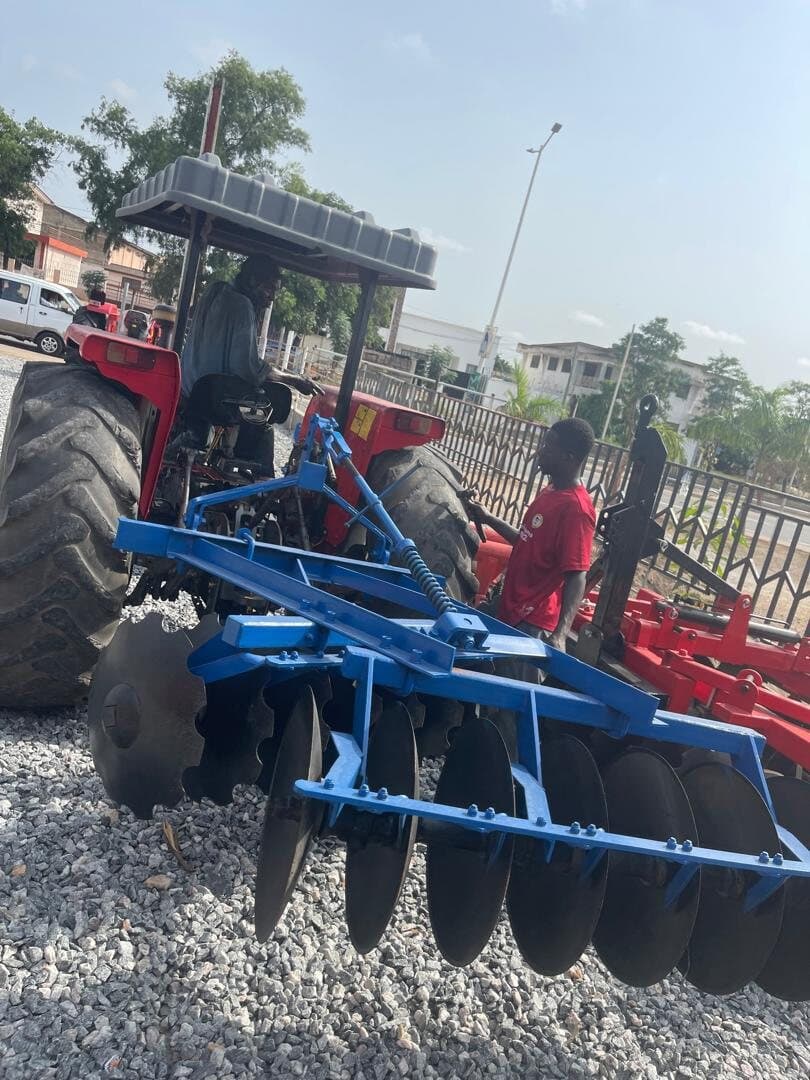 Laluna Enterprise team fitting a disc harrow to a tractor