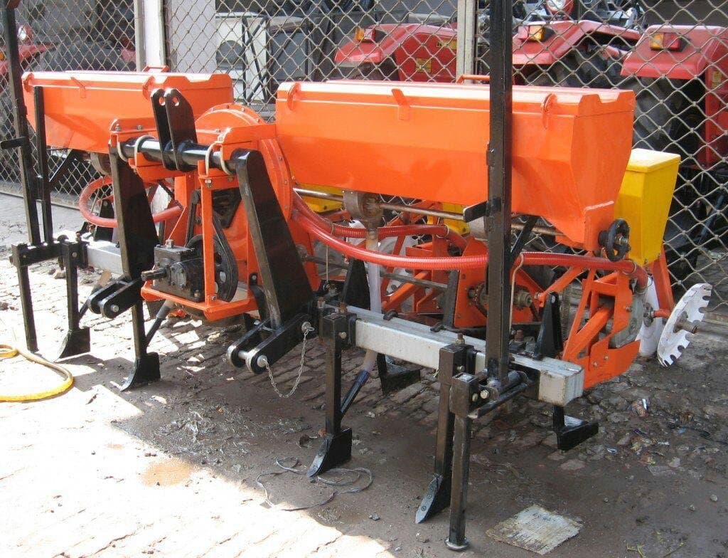 Close-up of an orange multi row seeder unit