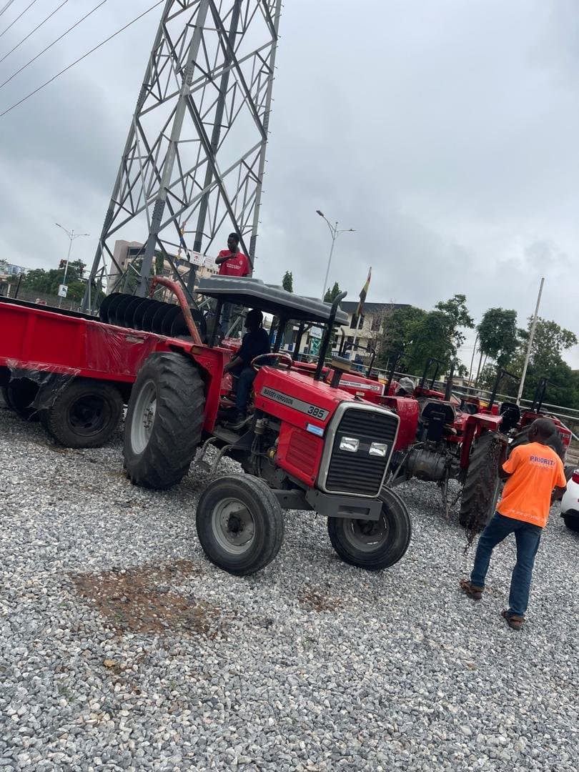 Fleet of tractors and trailers staged for delivery near a power pylon