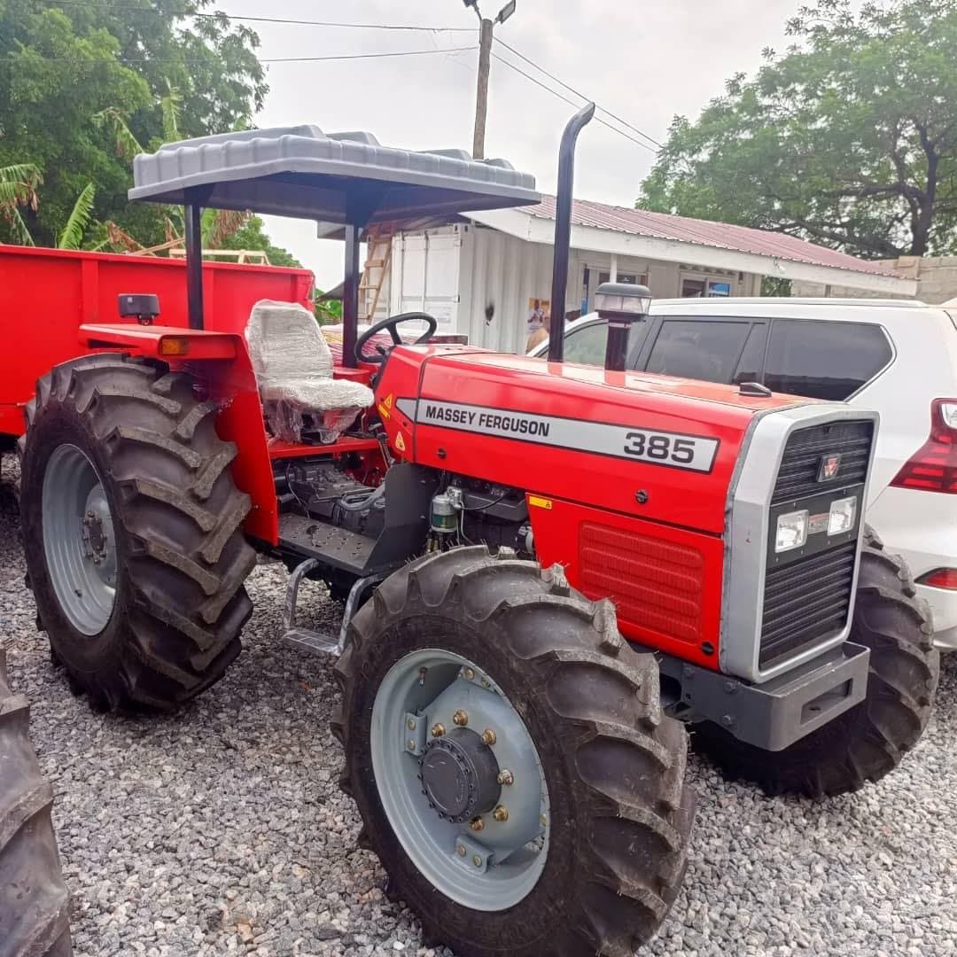 Massey Ferguson 385 tractor with canopy hitched to a trailer, ready for delivery