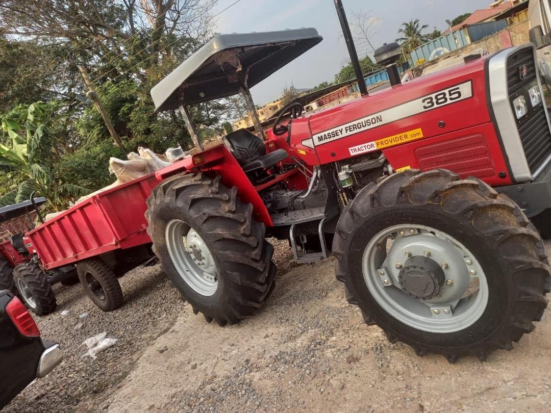 Massey Ferguson 385 tractor with canopy hitched to a loaded trailer