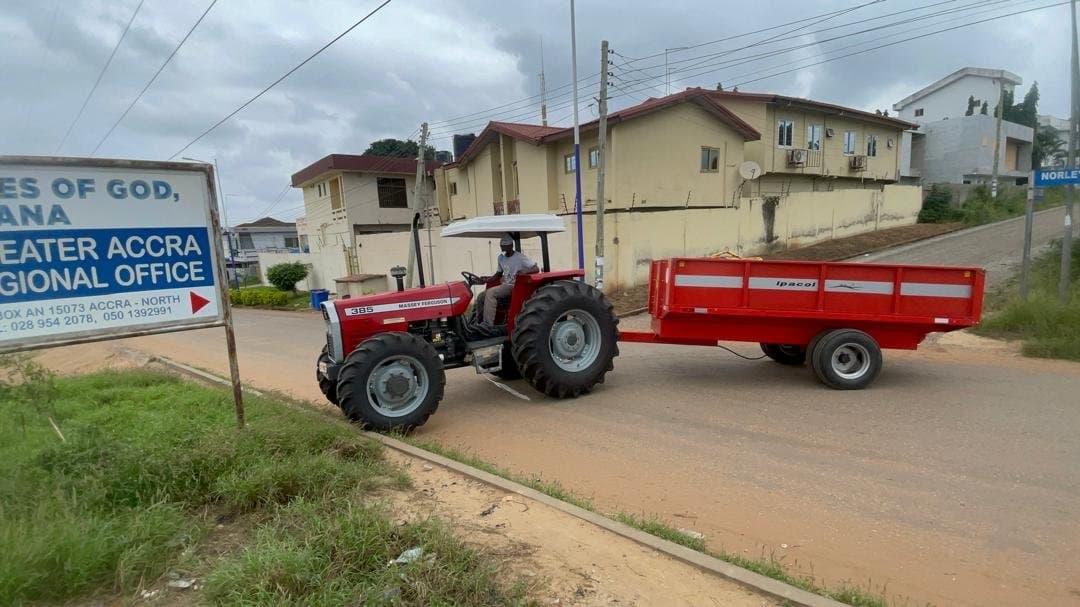 Massey Ferguson tractor towing a trailer on delivery along the road